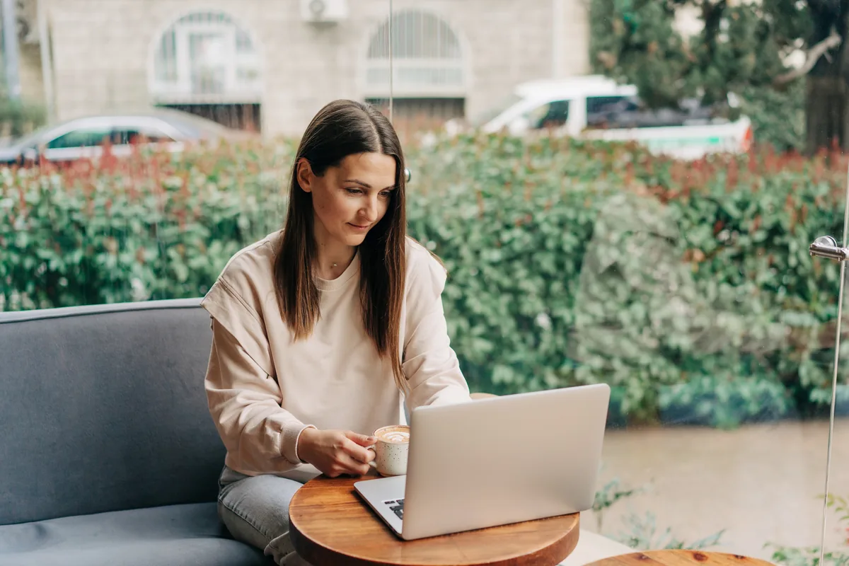 A freelancer working on a laptop at a café table