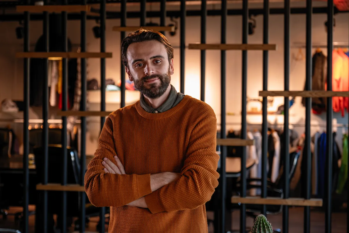 A boutique owner standing in his clothing store