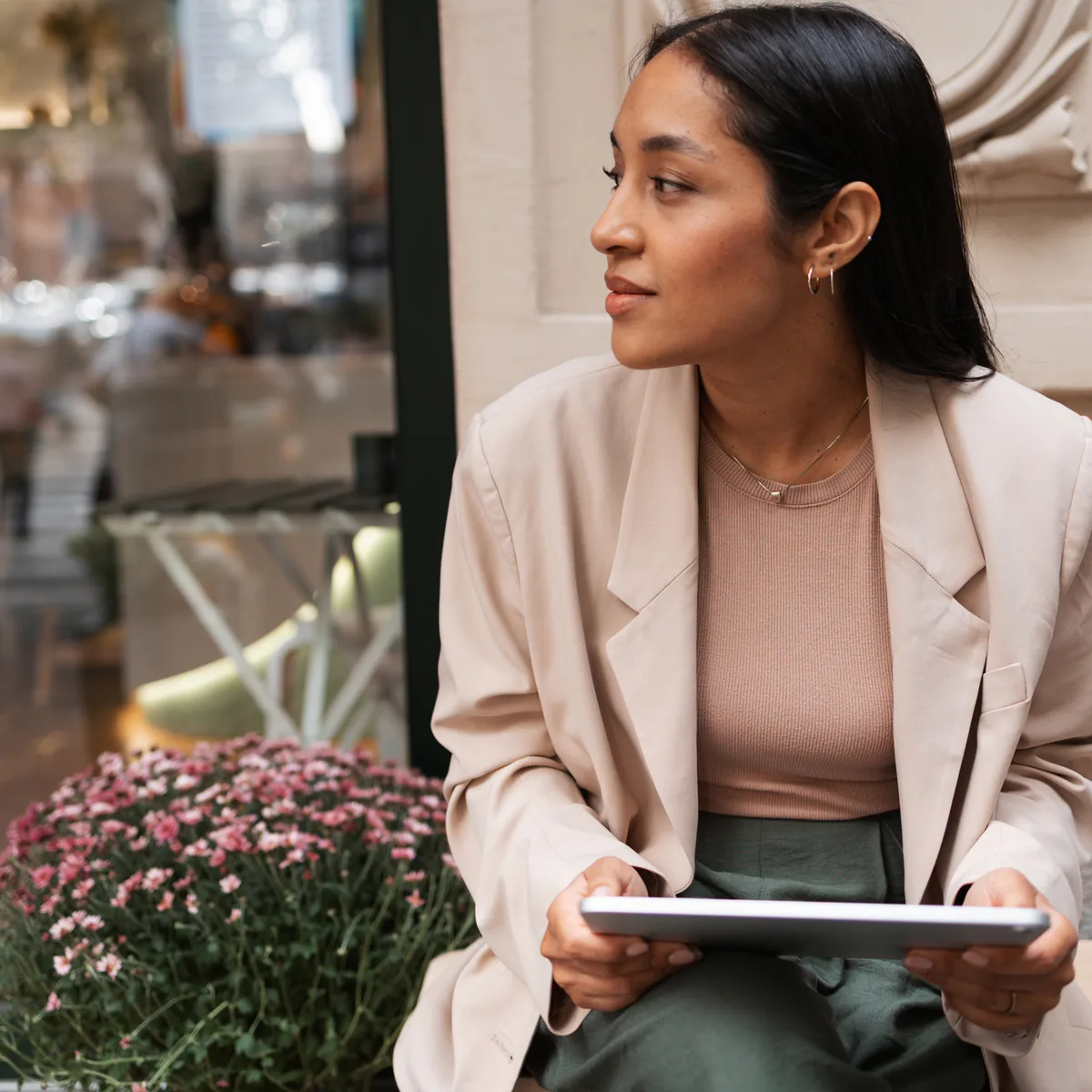 A small business owner working on a tablet outside her shop